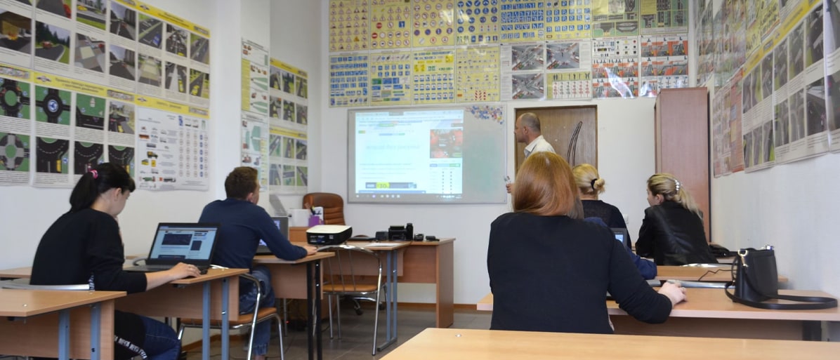 Teorikurs i ett klassrum med elever och lärare som undervisar vid en projektor.