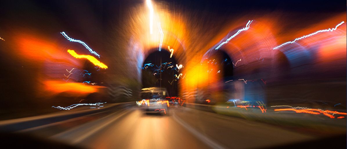 Bilkörning på natten med suddiga ljus och hastighetskänsla, vilket illustrerar effekten av fartblindhet