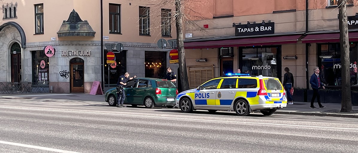 Polis utför trafikstopp av en bil på en stadsgata