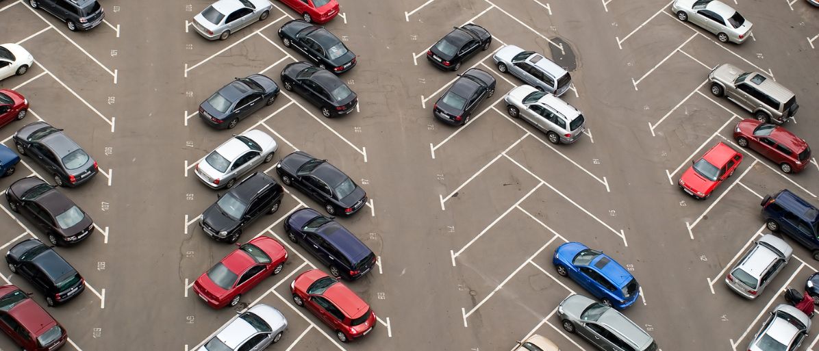 Fylld parkeringsplats med bilar ordnade i rader sedd uppifrån