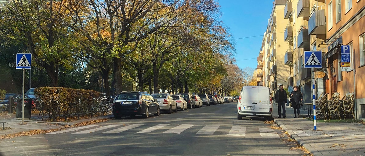 Ett övergångsställe i bostadsområde med parkerade bilar på båda sidor