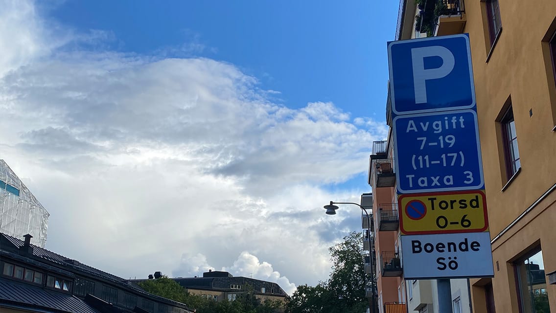 Parkeringsskylt med detaljer om avgifter och tider