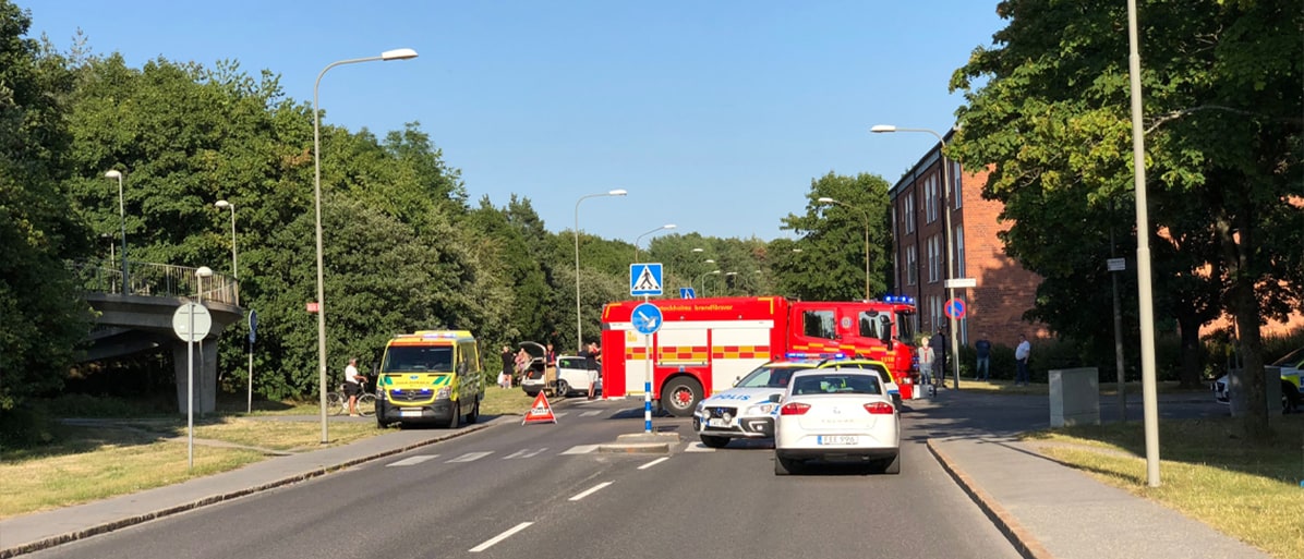 Trafikolycka på stadsgata med ambulans, brandbil och polis på plats