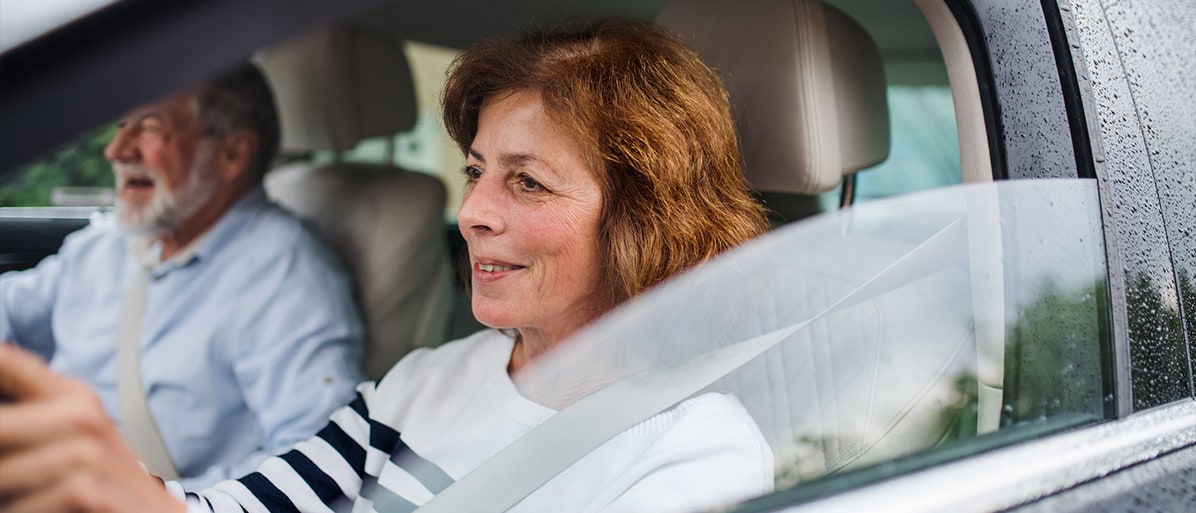 Kvinna kör bil och ler