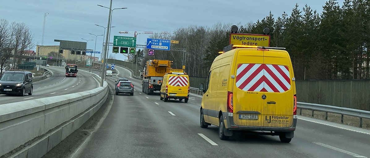 Trafik på en motorväg med arbetsfordon och skyltning för vägtransportledare