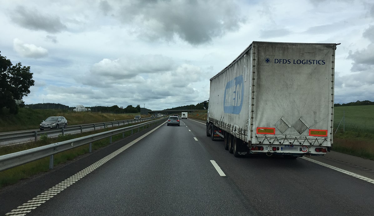 Bil kör om en lastbil på en motorväg med flera körfält
