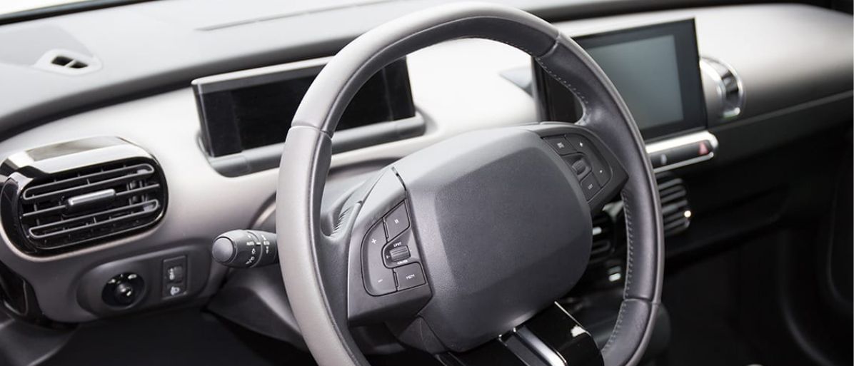 Närbild på bilens ratten med synliga kontroller för styrservo