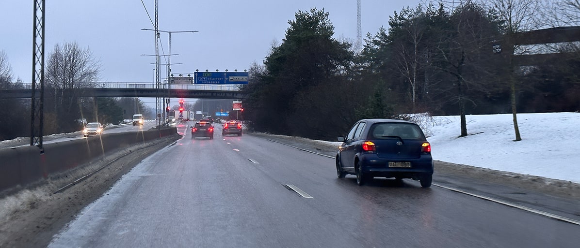 Bild av en bil som kör på en väg under regniga förhållanden