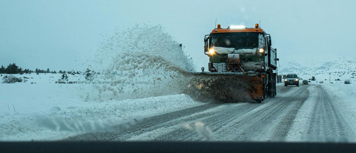 Underhållsfordon som plogar snö från vägen