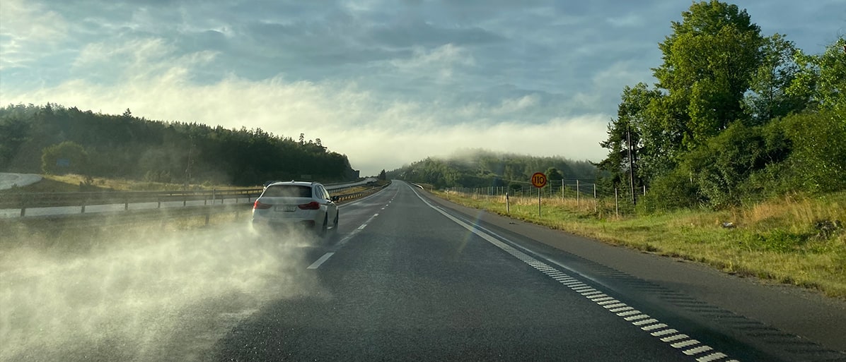 En bil på en väg med våt vägbeläggning